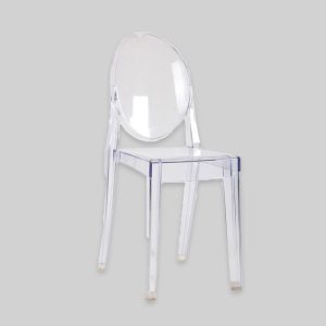 Clear ghost chairs set up for an elegant outdoor wedding ceremony with floral decorations